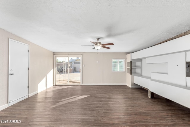 unfurnished living room featuring plenty of natural light, dark hardwood / wood-style flooring, and a textured ceiling