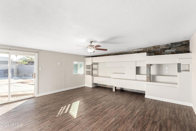 unfurnished living room with a textured ceiling, dark hardwood / wood-style floors, plenty of natural light, and ceiling fan