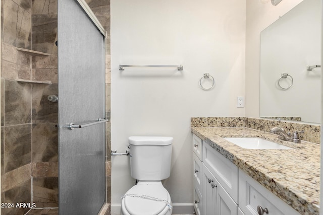 bathroom with vanity, toilet, and a shower with shower door