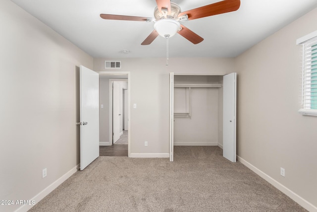 unfurnished bedroom featuring ceiling fan, light colored carpet, and a closet