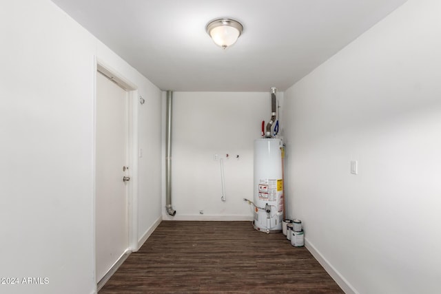 laundry area with dark hardwood / wood-style floors and water heater