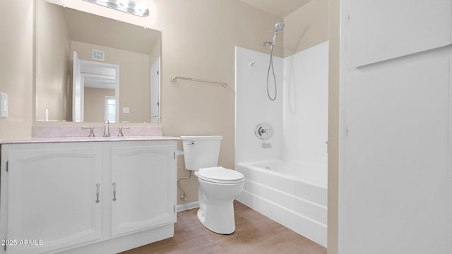 bathroom featuring visible vents, toilet, wood finished floors, tub / shower combination, and vanity