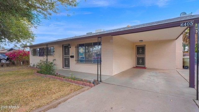 ranch-style house featuring a carport, a front yard, and driveway