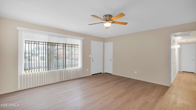 unfurnished room featuring visible vents, ceiling fan, light wood-style flooring, and baseboards