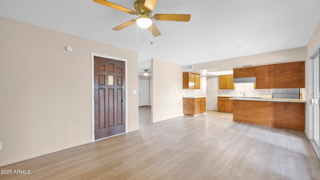 interior space featuring light wood finished floors, visible vents, and a ceiling fan