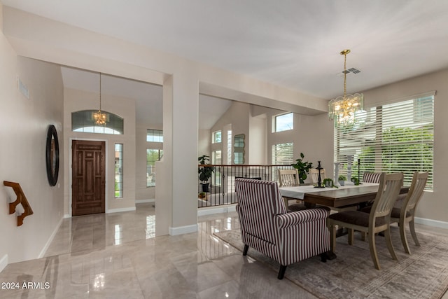 dining space with plenty of natural light, lofted ceiling, light tile patterned flooring, and a chandelier