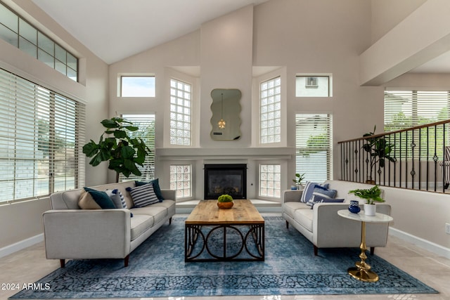 tiled living room with plenty of natural light and high vaulted ceiling