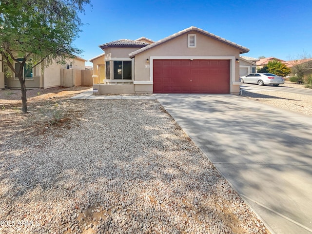 24811 W Wayland Dr, Buckeye, AZ 85326 - view of front of property featuring stucco siding, driveway, a tiled roof, and an attached garage