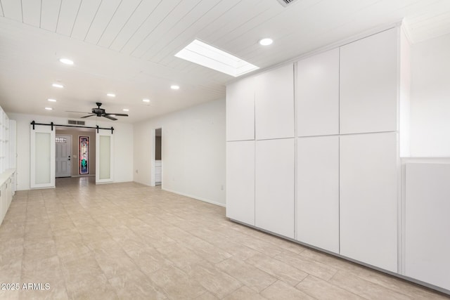 basement featuring a barn door and ceiling fan