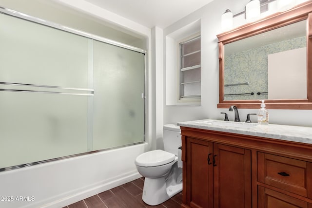 full bathroom with vanity, shower / bath combination with glass door, and toilet