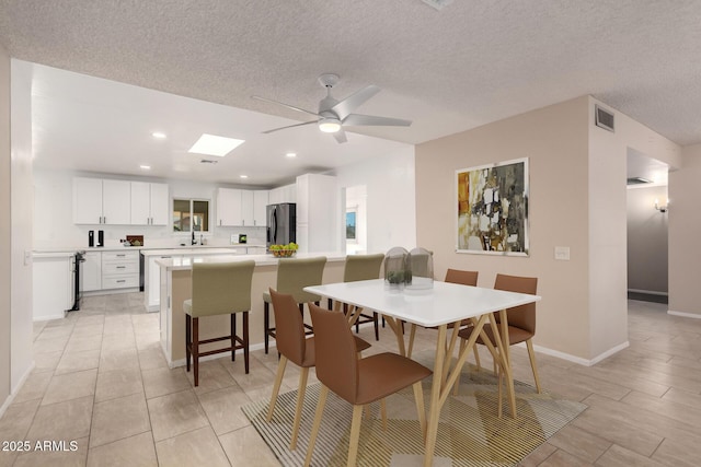 dining space featuring a textured ceiling and ceiling fan