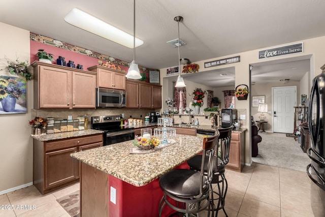 7015 W Melody Dr, Laveen, AZ 85339 - kitchen featuring stainless steel appliances, light stone countertops, decorative backsplash, and a center island