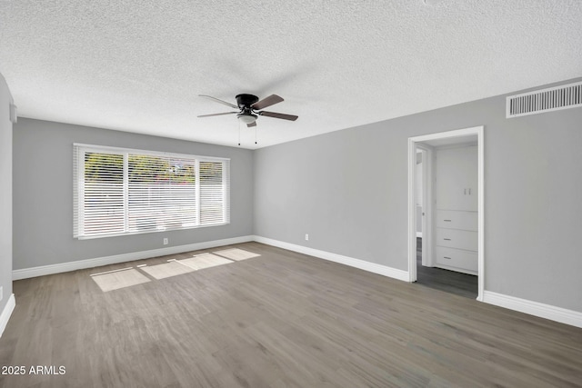 7039 N 15th St, Phoenix, AZ 85020 - unfurnished bedroom with baseboards, a textured ceiling, visible vents, ceiling fan, and wood finished floors
