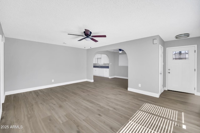 7039 N 15th St, Phoenix, AZ 85020 - unfurnished living room featuring a textured ceiling, wood finished floors, baseboards, and a ceiling fan