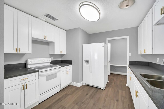 7039 N 15th St, Phoenix, AZ 85020 - kitchen with dark wood finished floors, dark countertops, white appliances, and visible vents