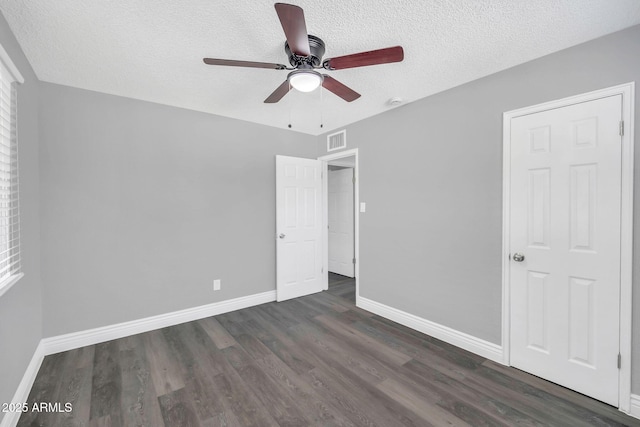 7039 N 15th St, Phoenix, AZ 85020 - unfurnished bedroom featuring a textured ceiling, baseboards, dark wood finished floors, and visible vents