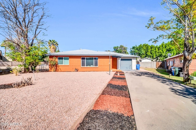 7039 N 15th St, Phoenix, AZ 85020 - view of front of property featuring brick siding, fence, a garage, and concrete driveway