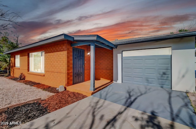 7039 N 15th St, Phoenix, AZ 85020 - property exterior at dusk featuring brick siding, driveway, and an attached garage