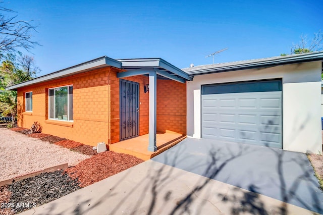 7039 N 15th St, Phoenix, AZ 85020 - view of front facade featuring brick siding, an attached garage, and concrete driveway