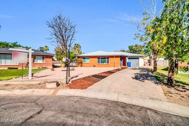 7039 N 15th St, Phoenix, AZ 85020 - ranch-style house featuring concrete driveway, a garage, and a front lawn