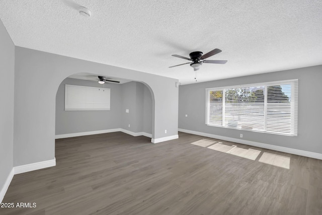 7039 N 15th St, Phoenix, AZ 85020 - unfurnished living room featuring ceiling fan, arched walkways, a textured ceiling, wood finished floors, and baseboards