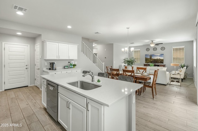 kitchen featuring a sink, visible vents, open floor plan, wood tiled floor, and dishwasher