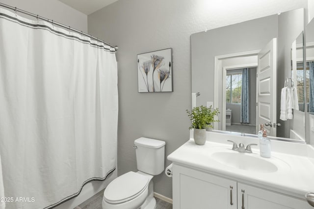 full bath with curtained shower, vanity, and toilet