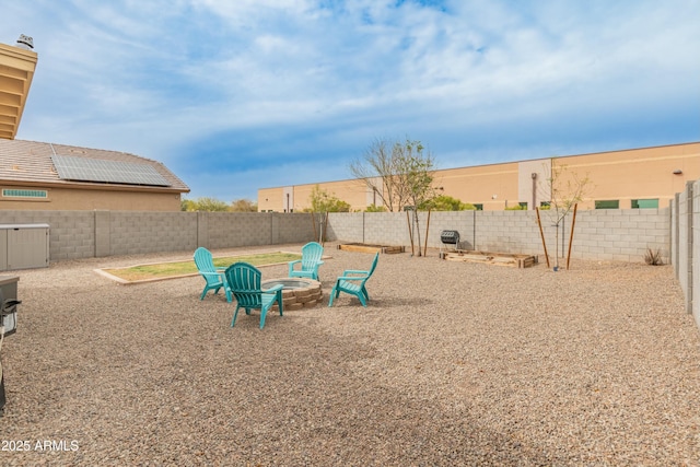 view of yard with a fenced backyard and a fire pit