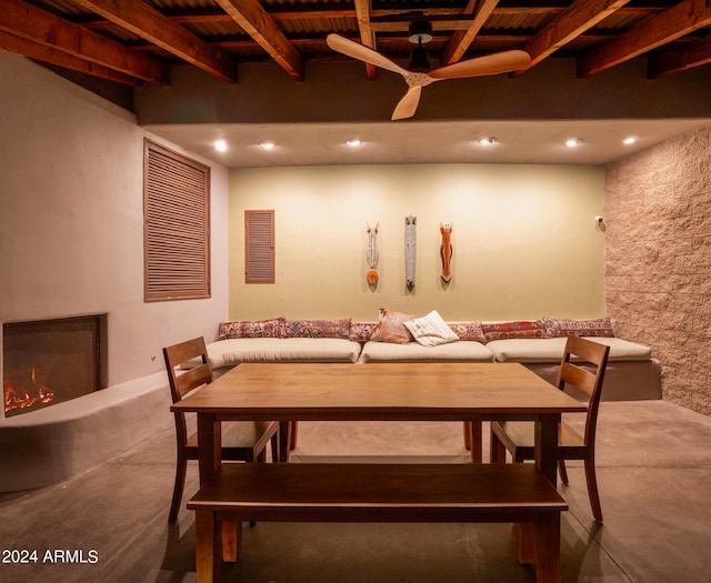 recreation room featuring beam ceiling and a large fireplace