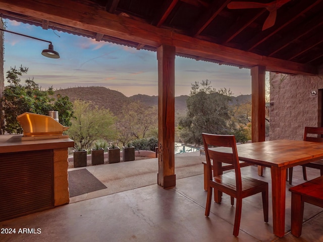 patio terrace at dusk featuring a mountain view