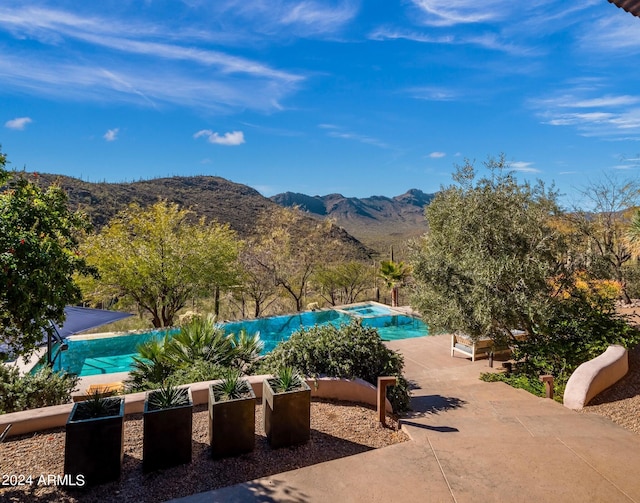 view of pool with a patio and a mountain view