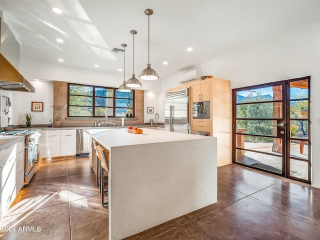 kitchen featuring plenty of natural light, hanging light fixtures, high end appliances, and a center island