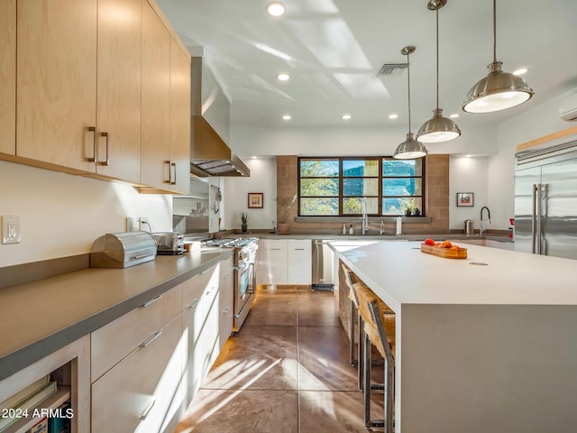 kitchen featuring sink, light brown cabinets, wall chimney exhaust hood, high quality appliances, and a large island