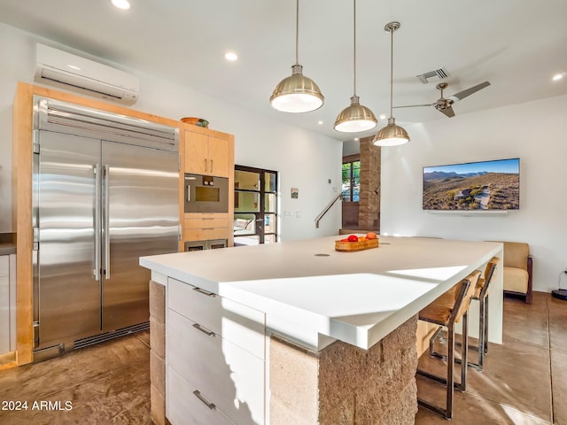 kitchen featuring an AC wall unit, stainless steel appliances, a kitchen island, light brown cabinetry, and ceiling fan