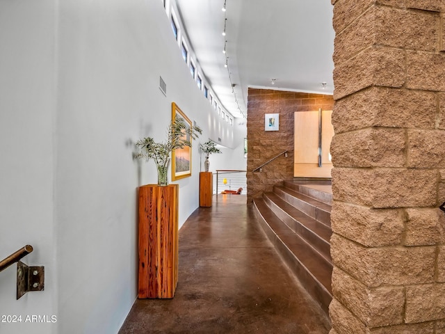 hall with concrete floors and rail lighting