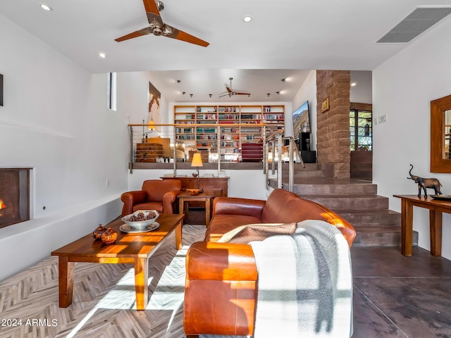 living room with ceiling fan and a large fireplace