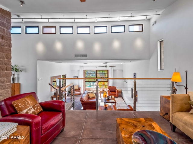 living room with ceiling fan and a towering ceiling