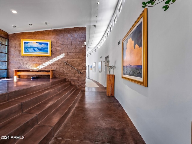 corridor with concrete flooring and vaulted ceiling