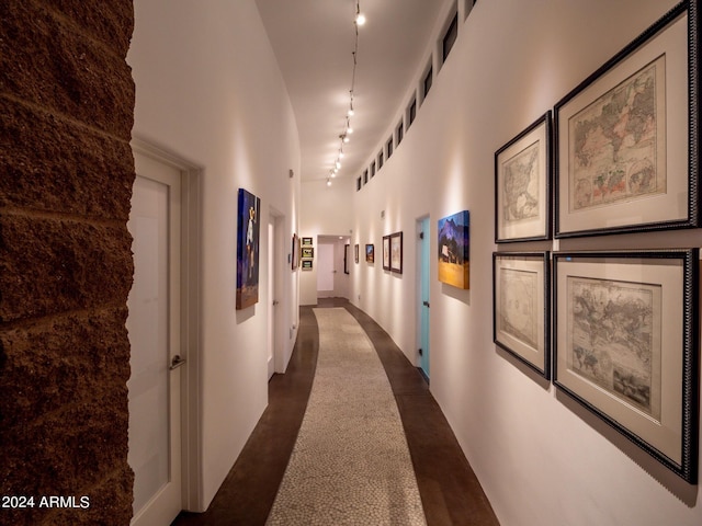 corridor with a towering ceiling and track lighting