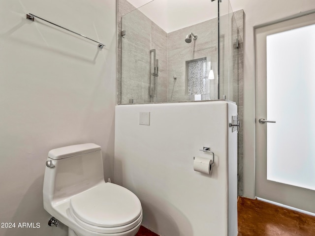 bathroom featuring a tile shower and toilet