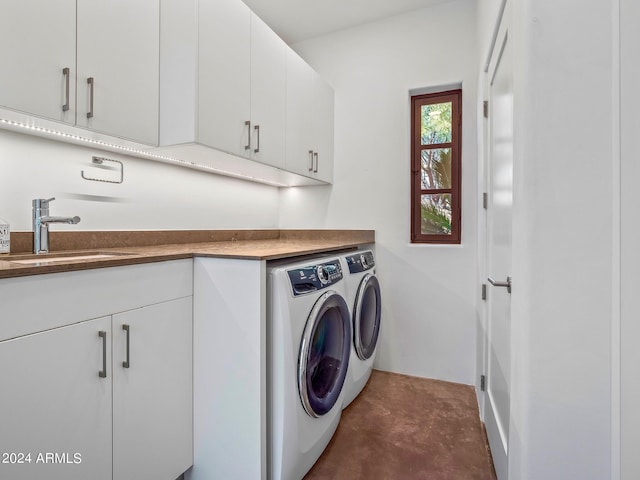 clothes washing area featuring sink, cabinets, and independent washer and dryer