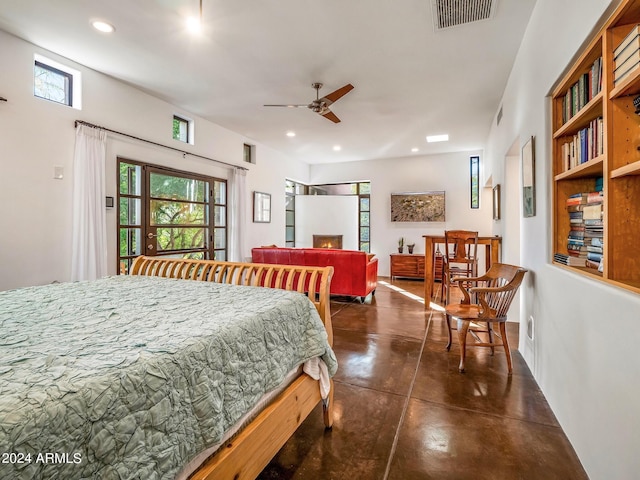 bedroom featuring a fireplace, multiple windows, and ceiling fan