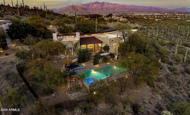 aerial view at dusk featuring a mountain view