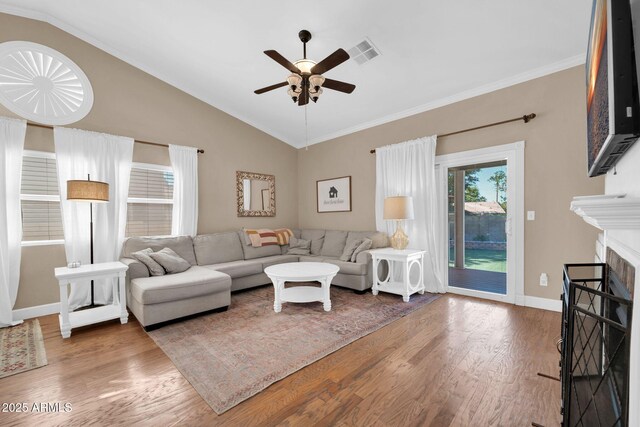 6708 W Utopia Rd, Glendale, AZ 85308 - living area featuring a ceiling fan, wood finished floors, vaulted ceiling, crown molding, and a fireplace