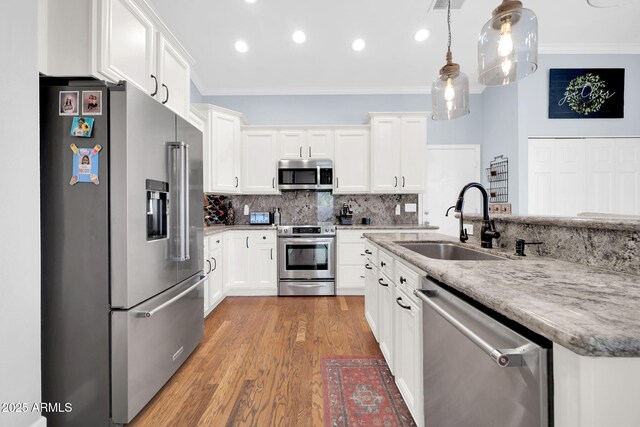 6708 W Utopia Rd, Glendale, AZ 85308 - kitchen with appliances with stainless steel finishes, ornamental molding, white cabinets, wood finished floors, and decorative backsplash