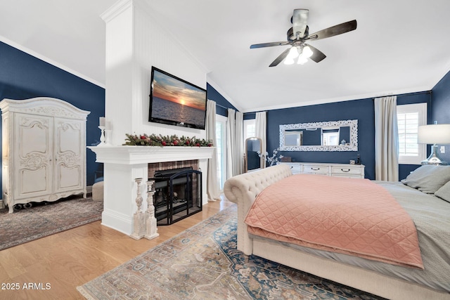 6708 W Utopia Rd, Glendale, AZ 85308 - bedroom featuring vaulted ceiling, crown molding, light wood-style flooring, a brick fireplace, and ceiling fan