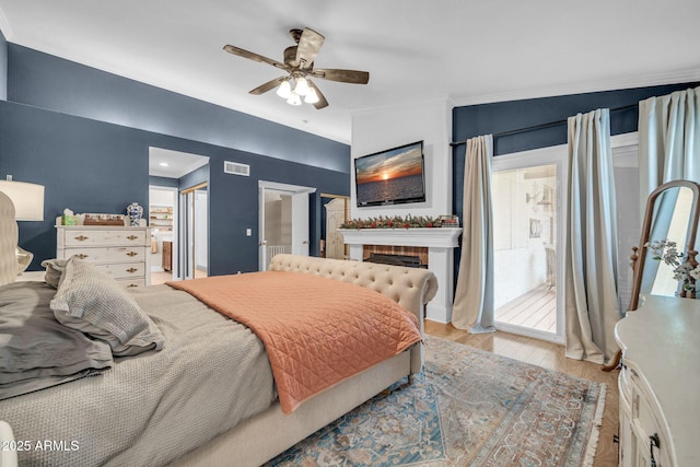 6708 W Utopia Rd, Glendale, AZ 85308 - bedroom with ornamental molding, wood finished floors, a brick fireplace, a ceiling fan, and ensuite bath
