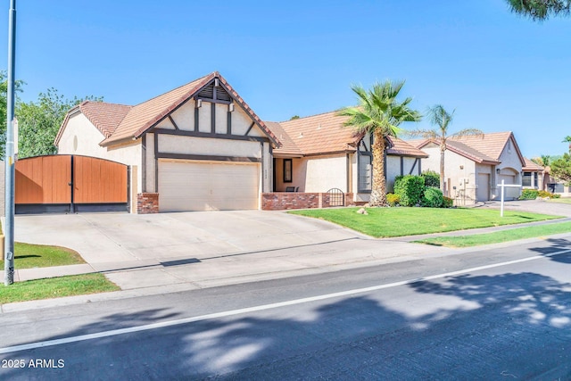 6708 W Utopia Rd, Glendale, AZ 85308 - tudor-style house with stucco siding, a garage, driveway, a gate, and a tile roof