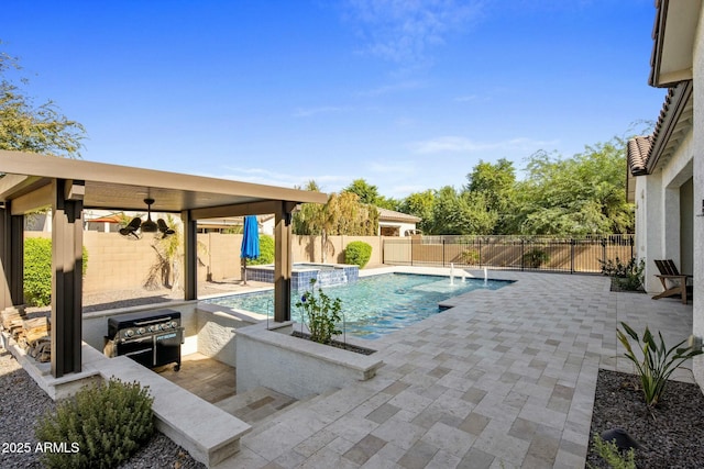 view of swimming pool with a patio area, a fenced backyard, a pool with connected hot tub, and a ceiling fan