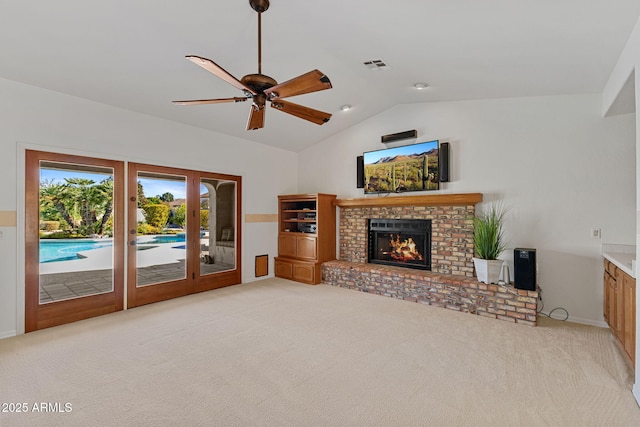 unfurnished living room featuring light carpet, vaulted ceiling, a fireplace, and visible vents